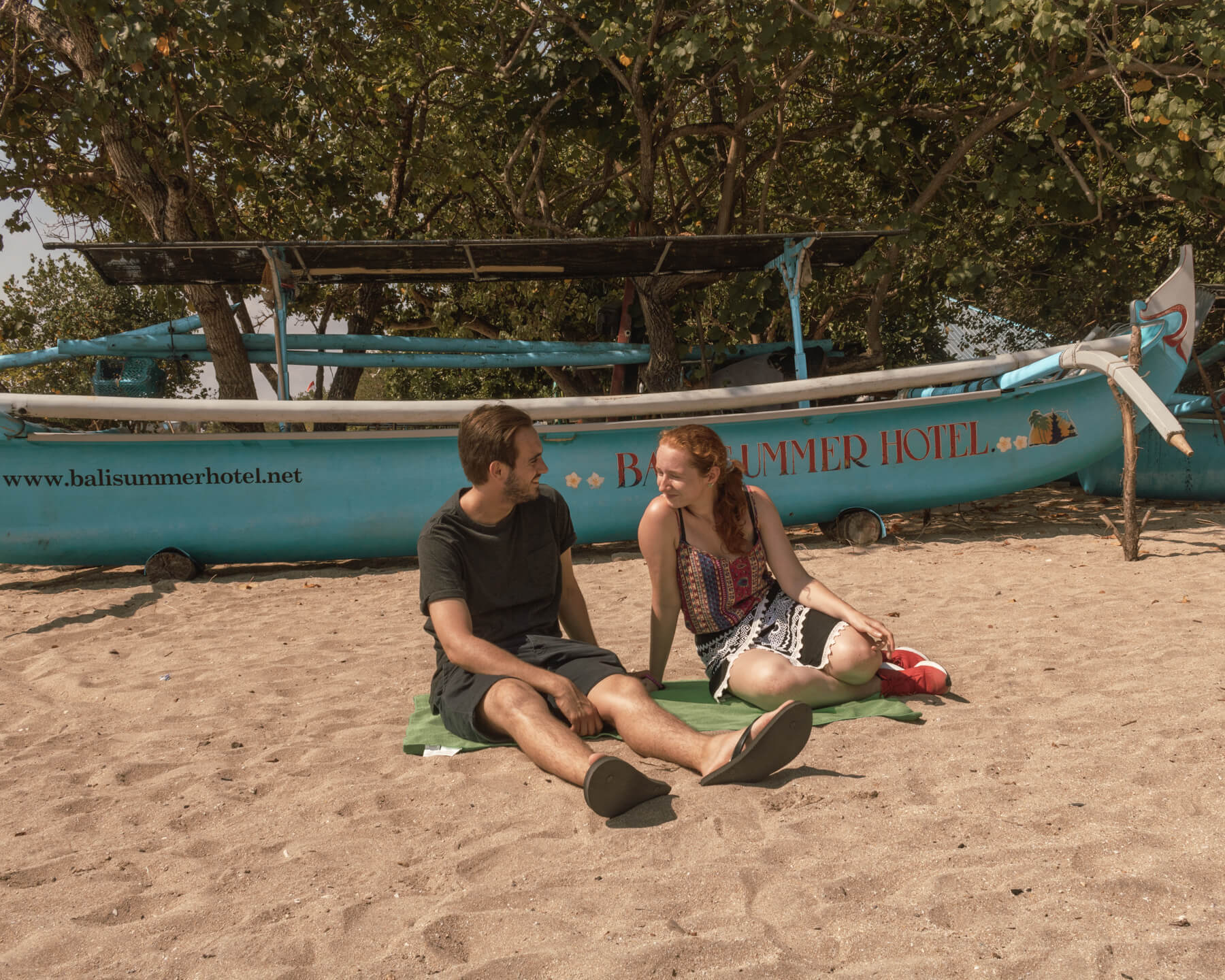 A couple sat on Kuta Beach in Bali, Indonesia, Asia